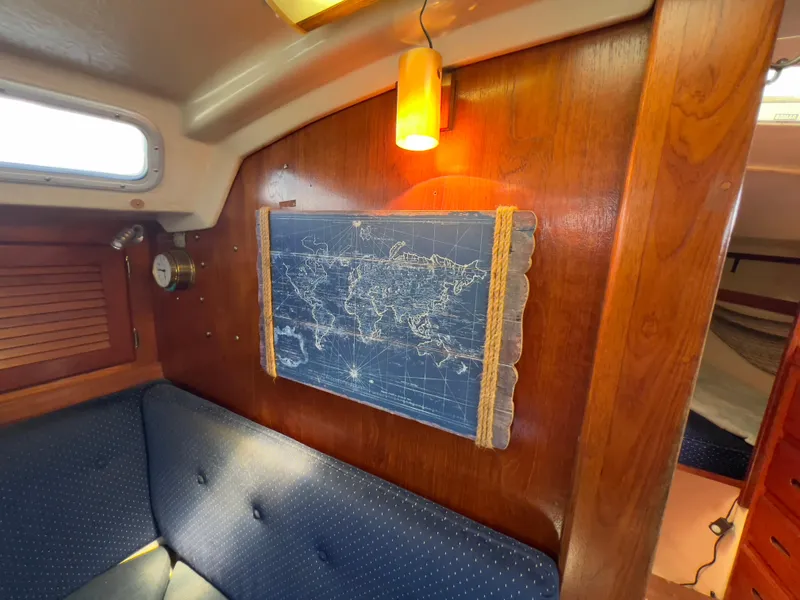 Slide: The Image of Interior of 1986 Catalina 30 sailboat with nautical map and cozy seating. - 22