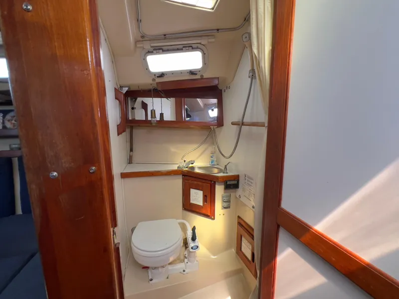 Slide: The Image of 1986 Catalina 30 sailboat bathroom with wooden accents and compact design. - 27