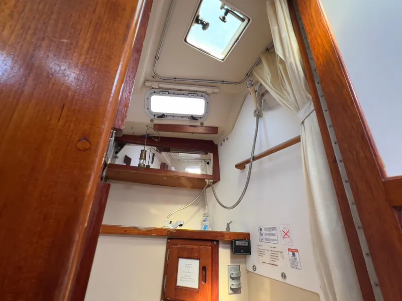 Slide: The Image of Interior of 1986 Catalina 30 sailboat with wooden finishes and overhead hatch. - 29