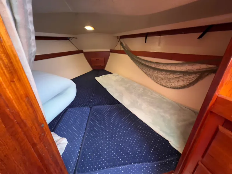 Slide: The Image of Cozy cabin interior of a 1986 Catalina 30 sailboat with blue cushions and wooden accents. - 30