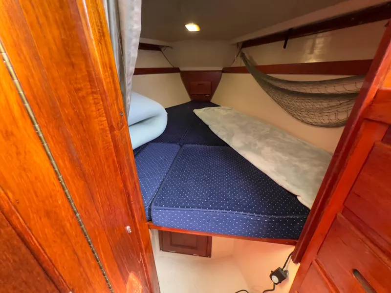 Slide: The Image of Cozy cabin interior of 1986 Catalina 30 sailboat with blue bedding and wooden finish. - 31