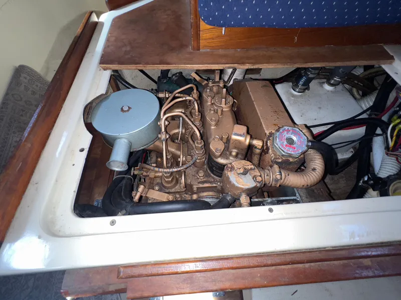 Slide: The Image of Engine compartment of a 1986 Catalina 30 sailboat, showcasing mechanical components and wiring. - 34