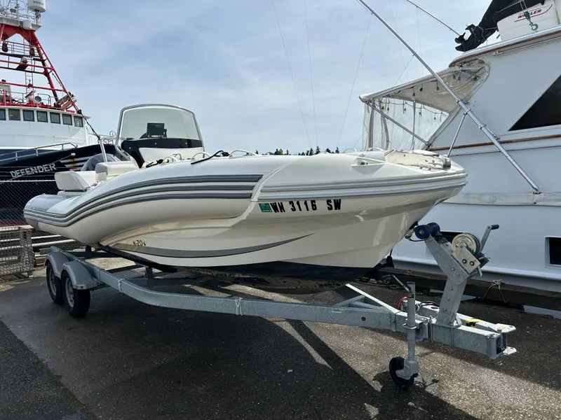 The Image of 2020 Zodiac N-Z0 680 boat on trailer, docked near other vessels. - 1
