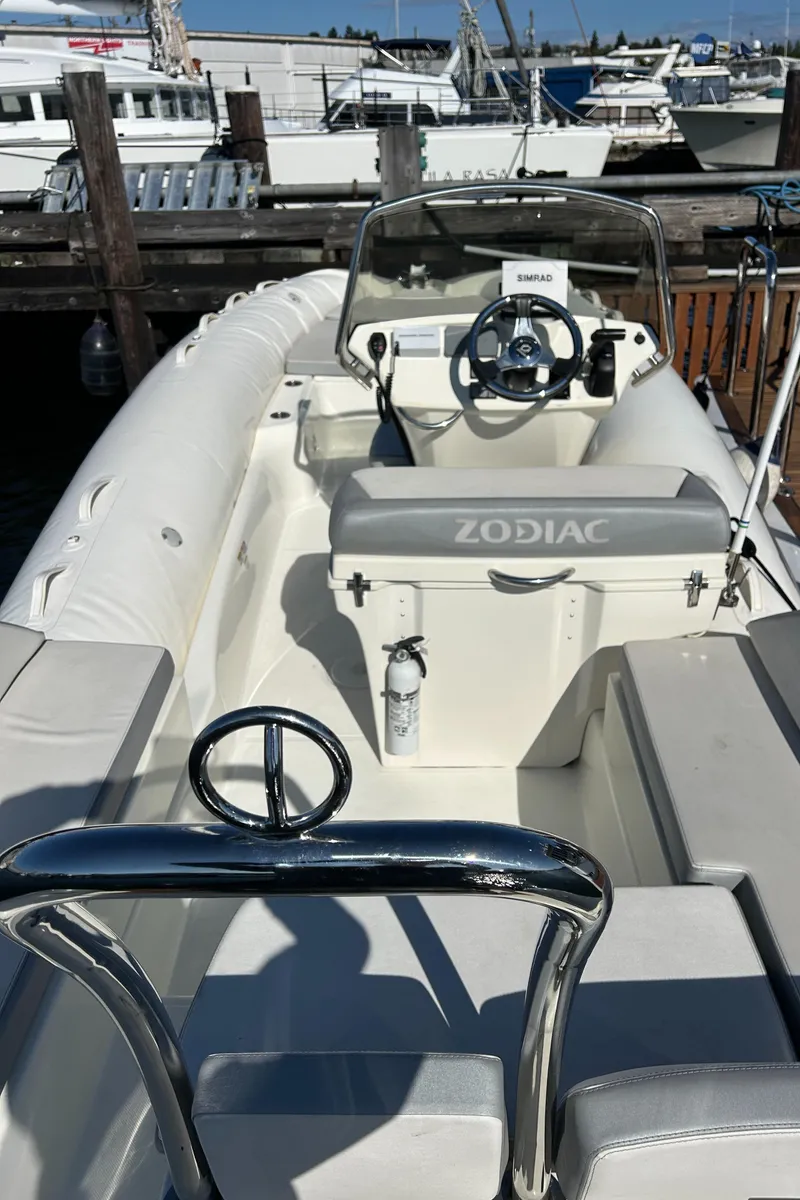 Slide: The Image of 2020 Zodiac N-Z0 680 boat docked, featuring steering wheel and seating area. - 6