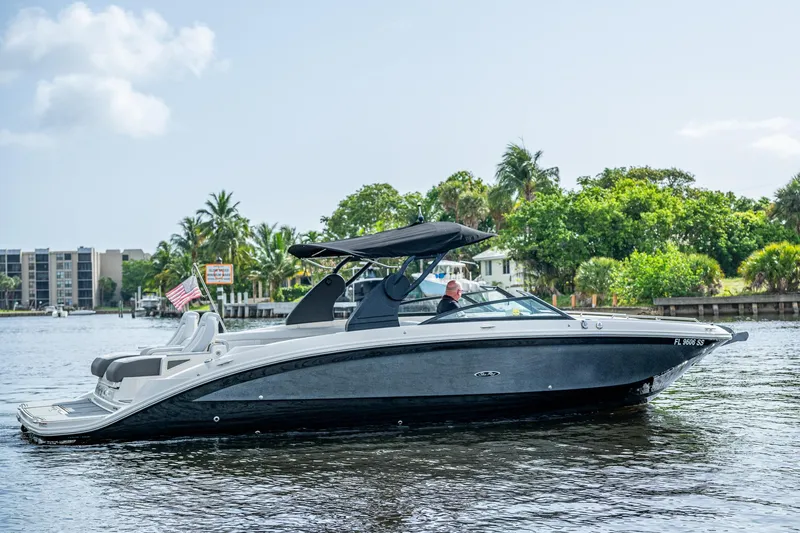 The Image of 2022 Sea Ray SDX 290 boat cruising on a scenic waterway with lush greenery. - 0