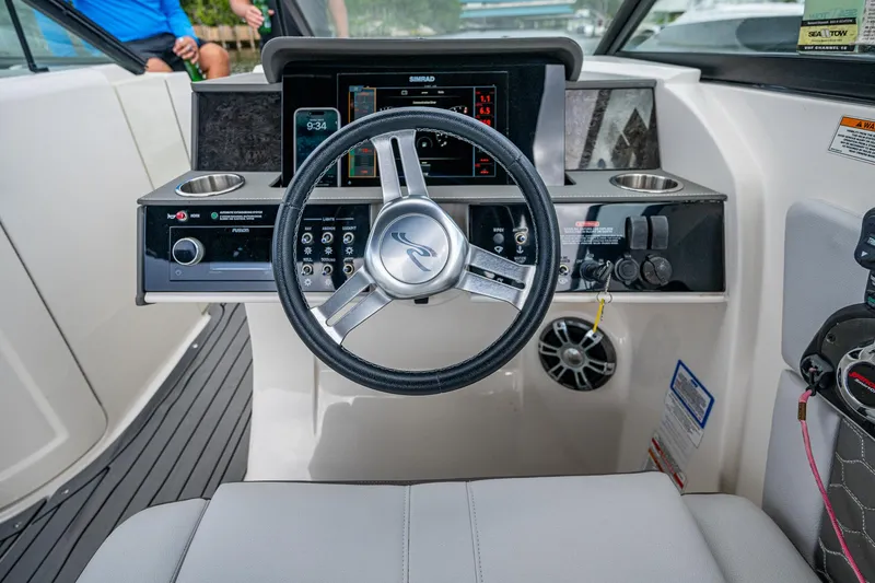 Slide: The Image of 2022 Sea Ray SDX 290 helm with modern steering wheel and dashboard controls. - 14