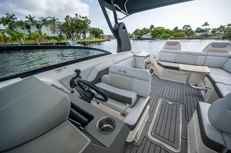 Slide: The Image of 2022 Sea Ray SDX 290 boat interior with luxurious seating and sleek design on a sunny day. - 16