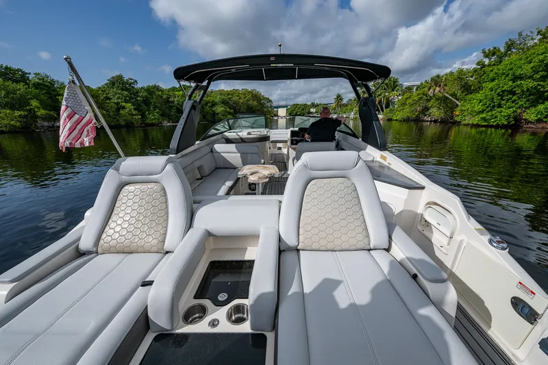 Slide: The Image of 2022 Sea Ray SDX 290 boat interior with luxurious seating on a calm river. - 18
