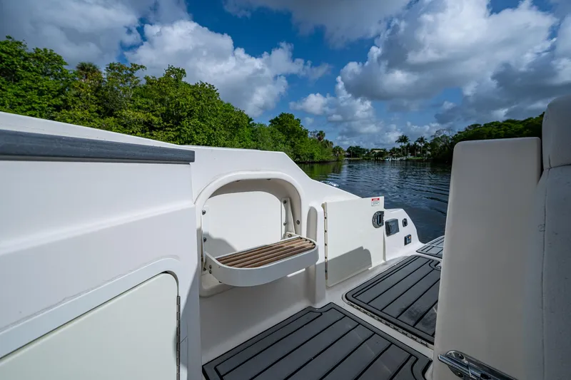 Slide: The Image of 2022 Sea Ray SDX 290 boat deck with scenic river view and lush greenery. - 19
