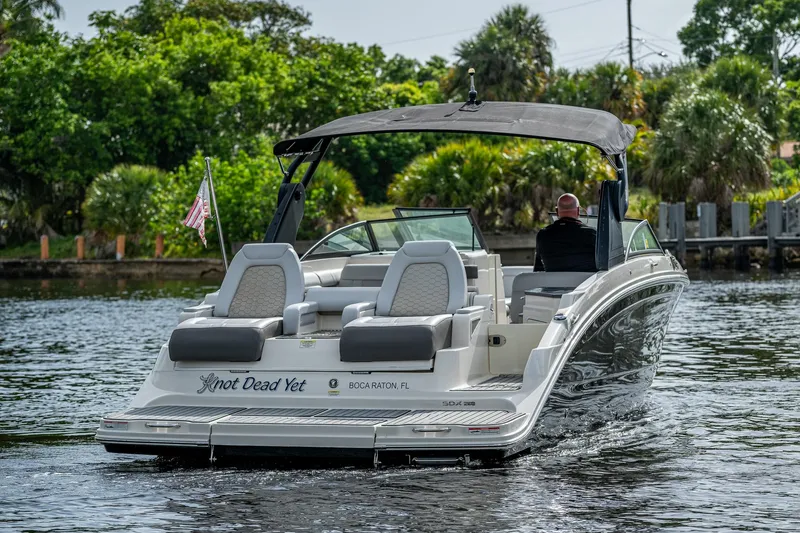 Slide: The Image of 2022 Sea Ray SDX 290 boat cruising on a scenic waterway. - 2