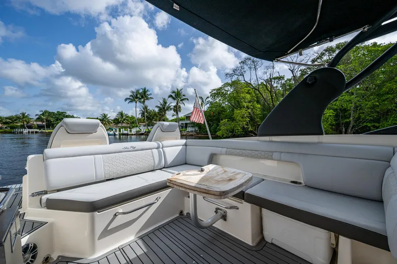 Slide: The Image of 2022 Sea Ray SDX 290 boat interior with seating, table, and scenic water view. - 24