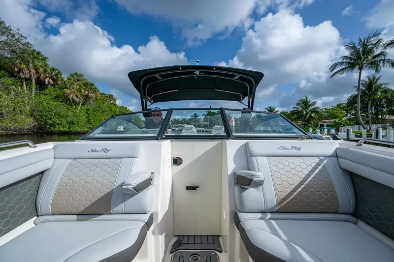 Slide: The Image of 2022 Sea Ray SDX 290 boat interior with luxurious seating, under a clear blue sky. - 26