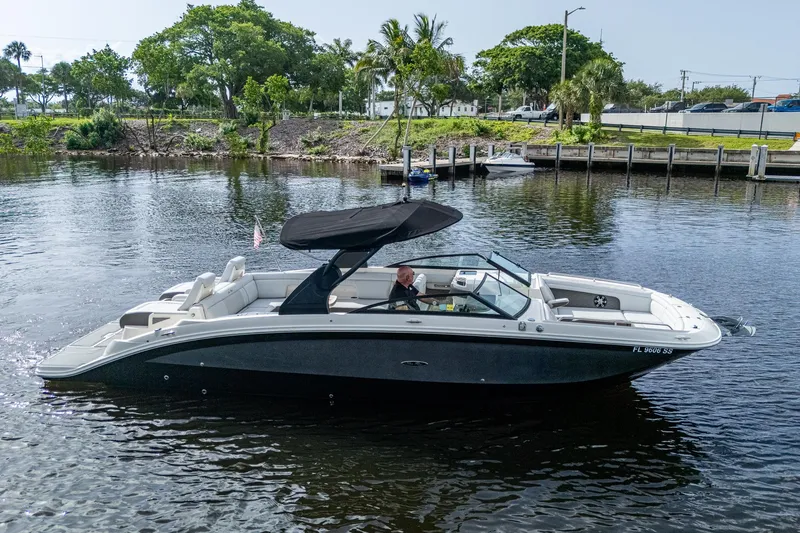 Slide: The Image of 2022 Sea Ray SDX 290 boat cruising on a calm river with lush greenery. - 36