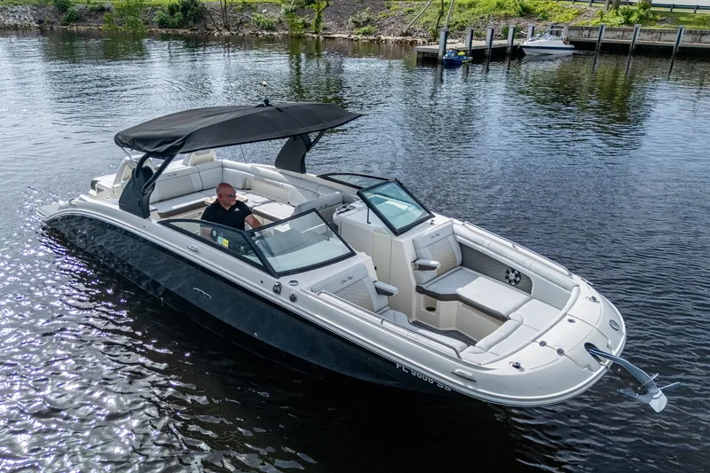 Slide: The Image of 2022 Sea Ray SDX 290 boat cruising on a calm river. - 37