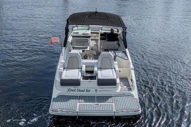 Slide: The Image of 2022 Sea Ray SDX 290 boat on water, rear view with American flag. - 40
