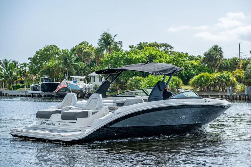 Slide: The Image of 2022 Sea Ray SDX 290 boat cruising on a scenic waterway with lush greenery. - 5