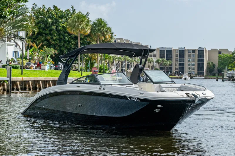 Slide: The Image of 2022 Sea Ray SDX 290 boat cruising on a sunny waterfront. - 6