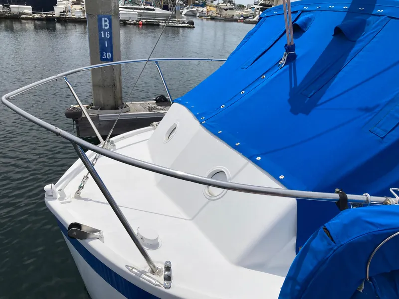 Slide: The Image of 1963 Sumnercraft 31 Motor Sailer with blue cover docked at marina. - 11