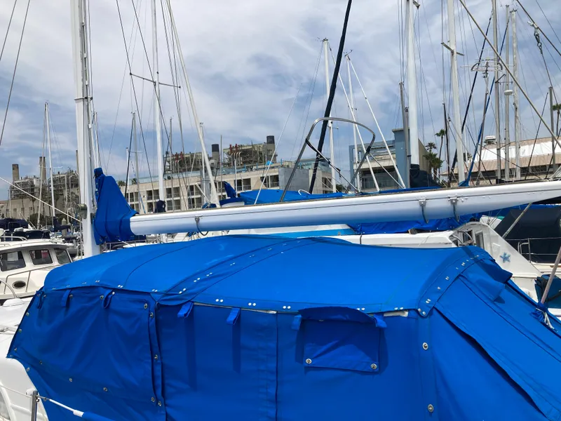 Slide: The Image of 1963 Sumnercraft 31 Motor Sailer with blue cover docked at marina. - 12