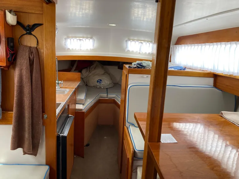 Slide: The Image of Interior of 1963 Sumnercraft 31 Motor Sailer with wood finish and cozy seating area. - 15