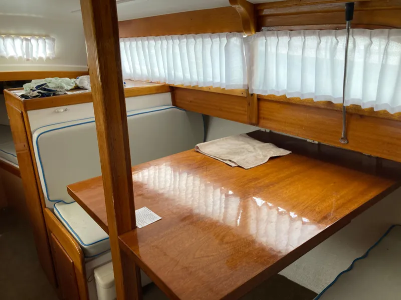 Slide: The Image of Interior of 1963 Sumnercraft 31 Motor Sailer with wooden table and seating. - 16