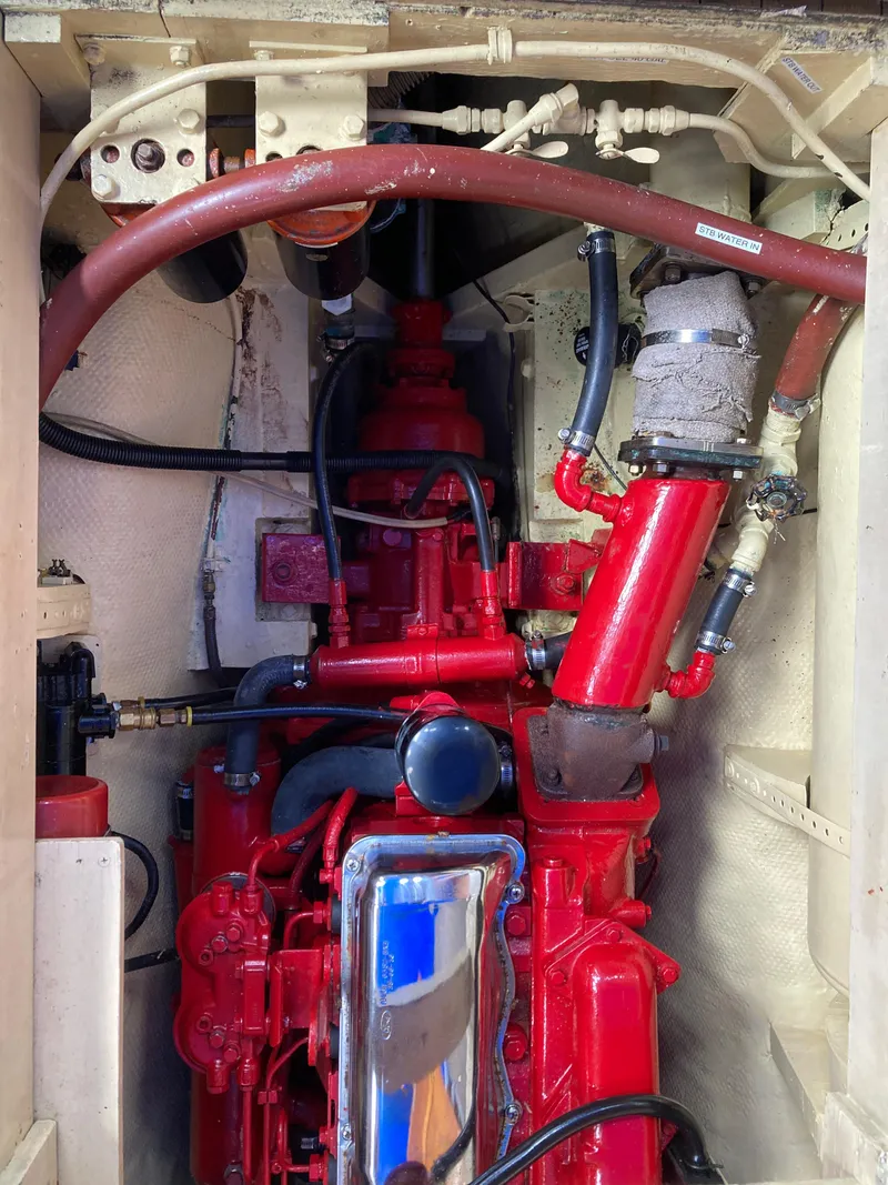 Slide: The Image of Engine compartment of a 1963 Sumnercraft 31 Motor Sailer, featuring a red-painted engine. - 32