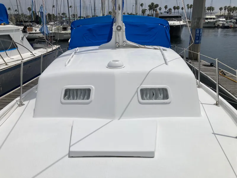 Slide: The Image of 1963 Sumnercraft 31 Motor Sailer with blue covers docked at a marina. - 9