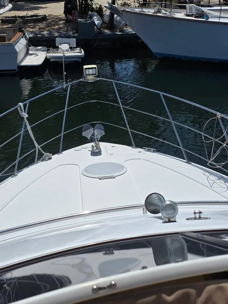 Slide: The Image of 2000 Carver 396 Motor Yacht bow view at marina, surrounded by watercraft. - 11