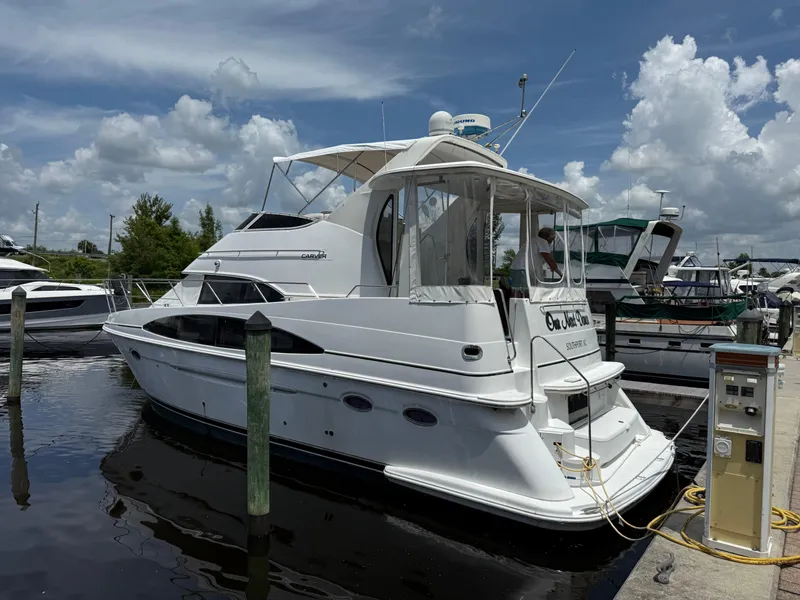 Slide: The Image of 2001 Carver 396 Motor Yacht docked at marina under blue sky. - 2