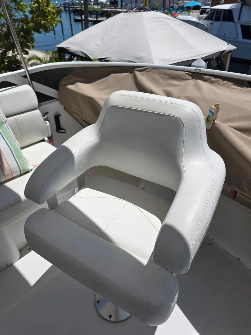 Slide: The Image of White captain's chair on 2000 Carver 396 Motor Yacht deck, marina background. - 21