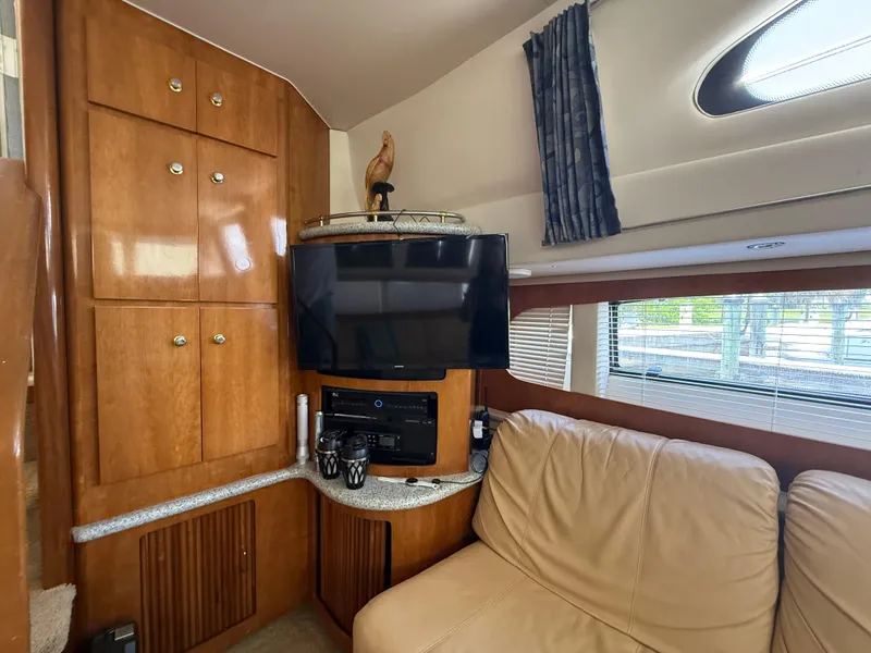 Slide: The Image of Interior of 2001 Carver 396 Motor Yacht with TV, cabinets, and beige seating. - 33