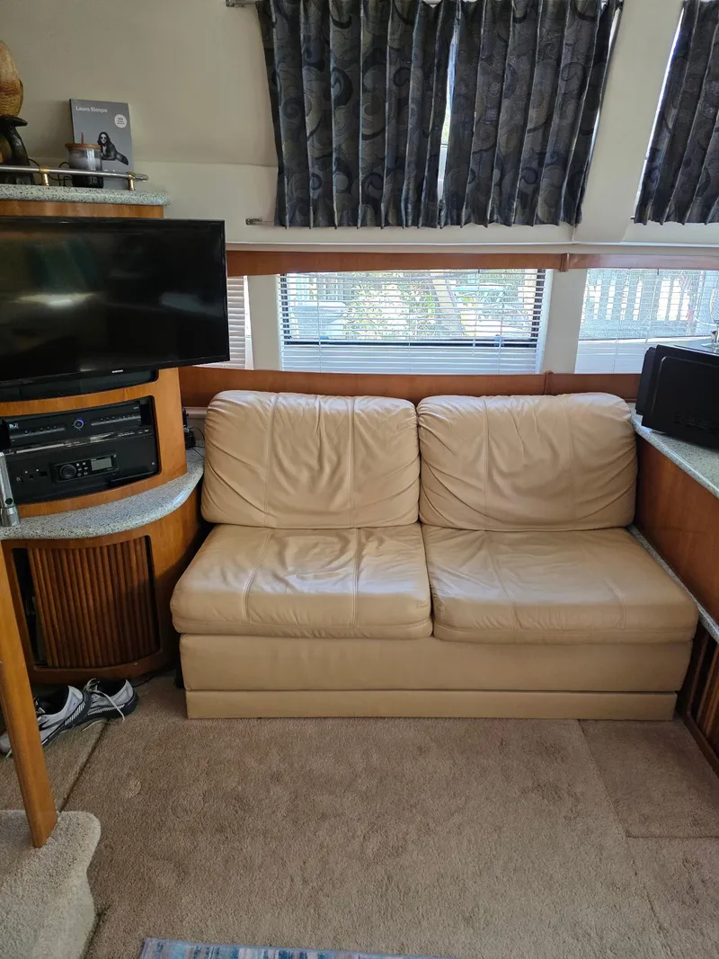 Slide: The Image of Interior of 2000 Carver 396 Motor Yacht with beige leather sofa and entertainment system. - 36