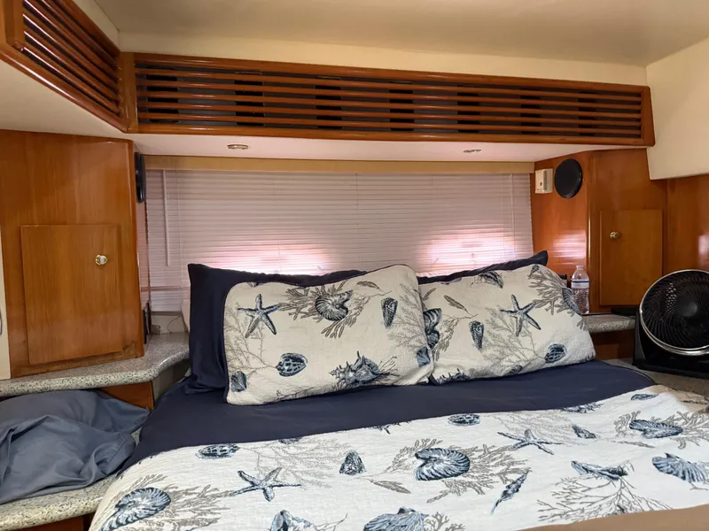 Slide: The Image of Interior of 2001 Carver 396 Motor Yacht bedroom with nautical-themed bedding and wooden cabinetry. - 46