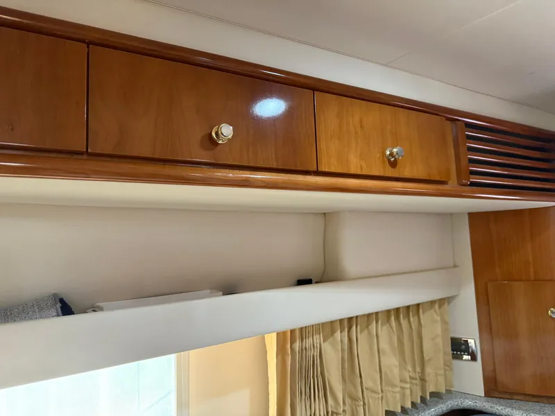 Slide: The Image of Interior of 2001 Carver 396 Motor Yacht with wooden cabinets and beige curtains. - 47