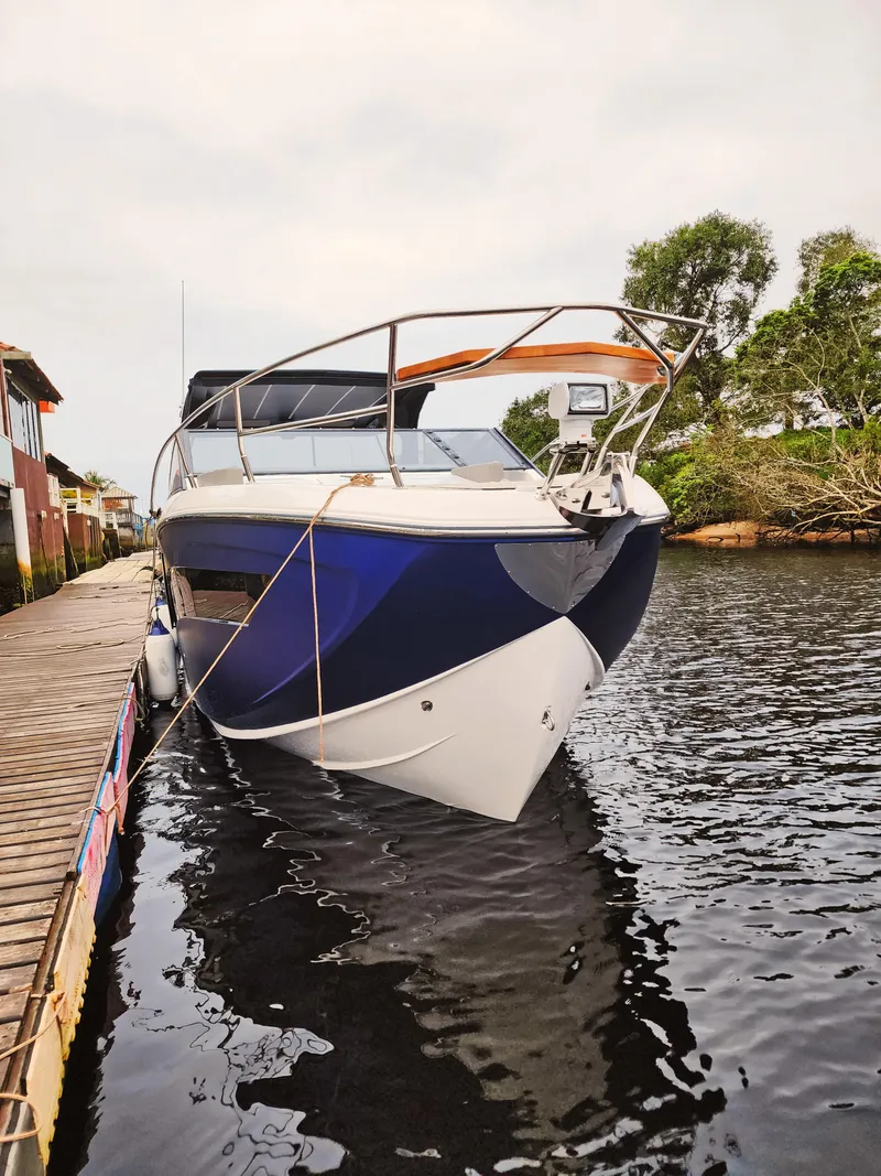Slide: The Image of 2025 Hanover 347 Inboard boat docked on calm water, surrounded by trees. - 7