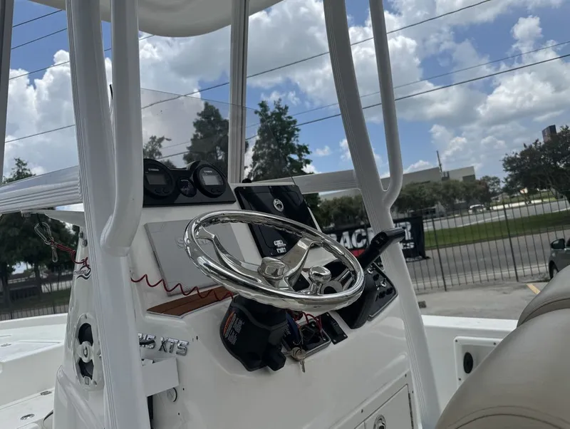 Slide: The Image of NauticStar 215 Bay 2022 boat seat with motor in background. - 13