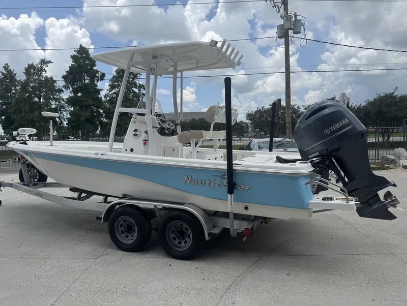 Slide: The Image of 2022 NauticStar 215 Bay boat on trailer under cloudy sky. - 2
