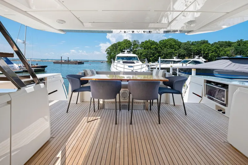 Slide: The Image of Luxurious 2018 Ferretti Yachts 780 deck with elegant dining area, overlooking serene marina. - 29