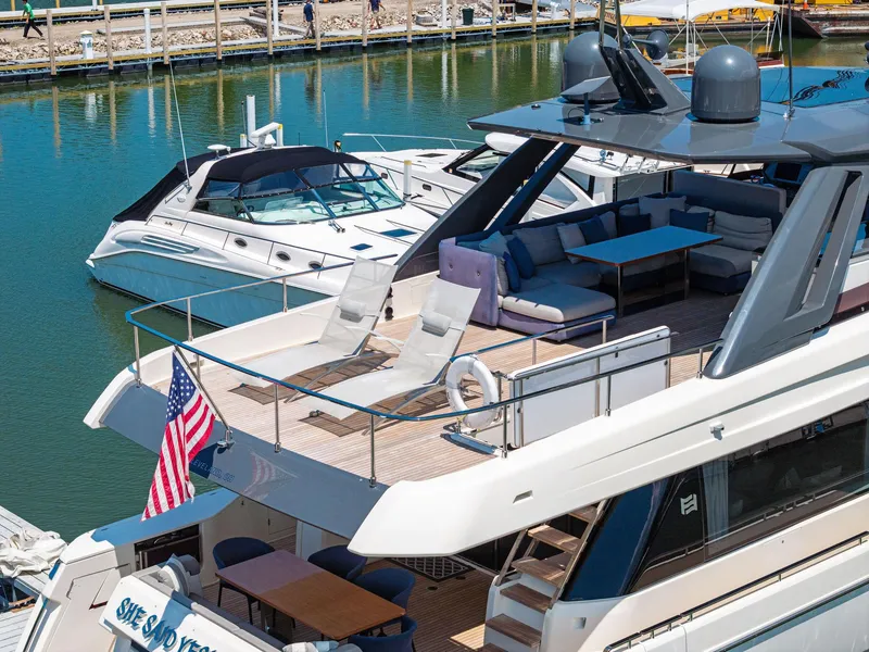 Slide: The Image of 2018 Ferretti Yachts 780 docked, featuring spacious deck with seating and American flag. - 5