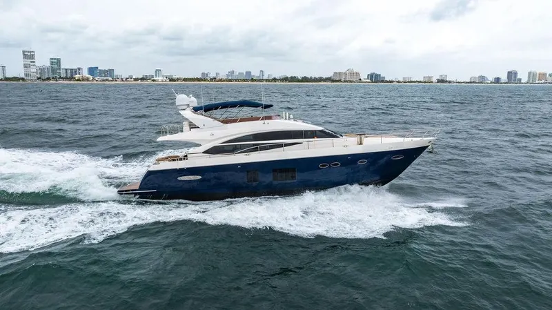 Slide: The Image of 2012 Princess 72 Motor Yacht cruising on open water, city skyline in background. - 10