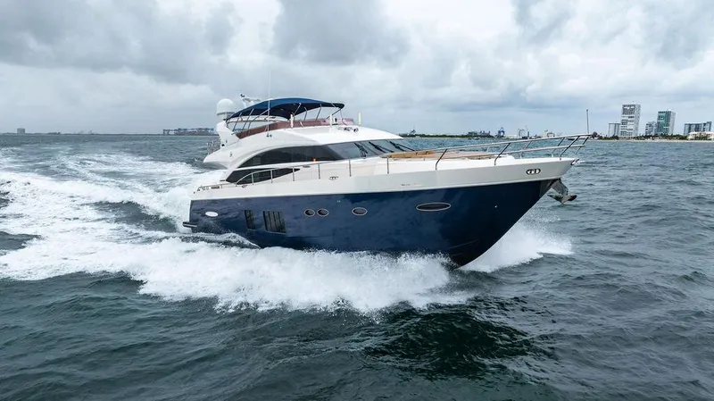 Slide: The Image of 2012 Princess 72 Motor Yacht cruising on open water, with city skyline in background. - 11