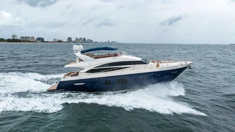 Slide: The Image of 2012 Princess 72 Motor Yacht cruising on open water, city skyline in background. - 2