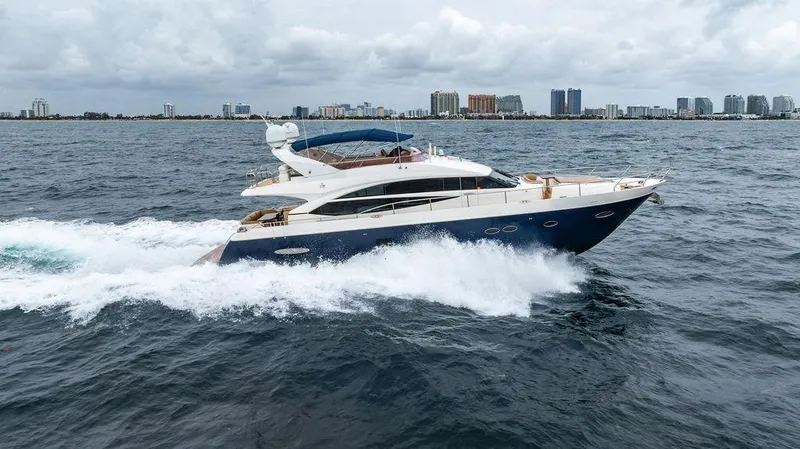 Slide: The Image of 2012 Princess 72 Motor Yacht cruising on open water with city skyline in background. - 20