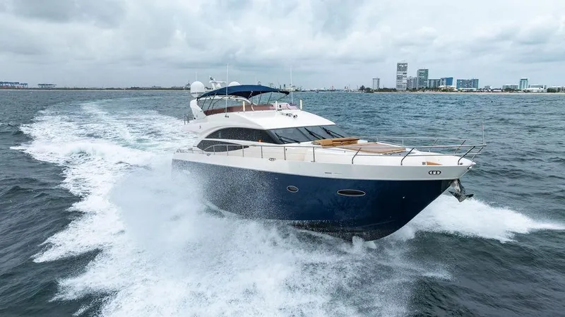 Slide: The Image of 2012 Princess 72 Motor Yacht cruising on open water, city skyline in background. - 9