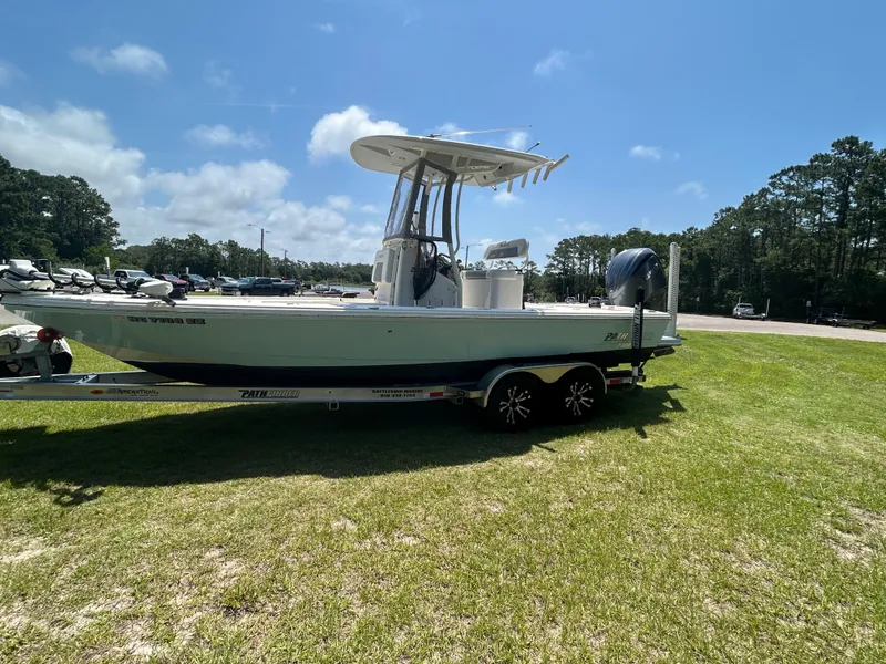 The Image of 2023 Pathfinder 2300 HPS boat on trailer, parked on grass under clear sky. - 0