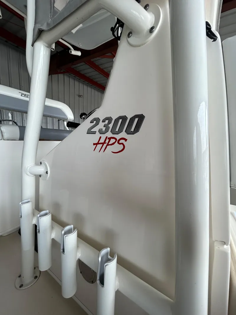 Slide: The Image of 2023 Pathfinder 2300 HPS boat interior with rod holders in a storage facility. - 11