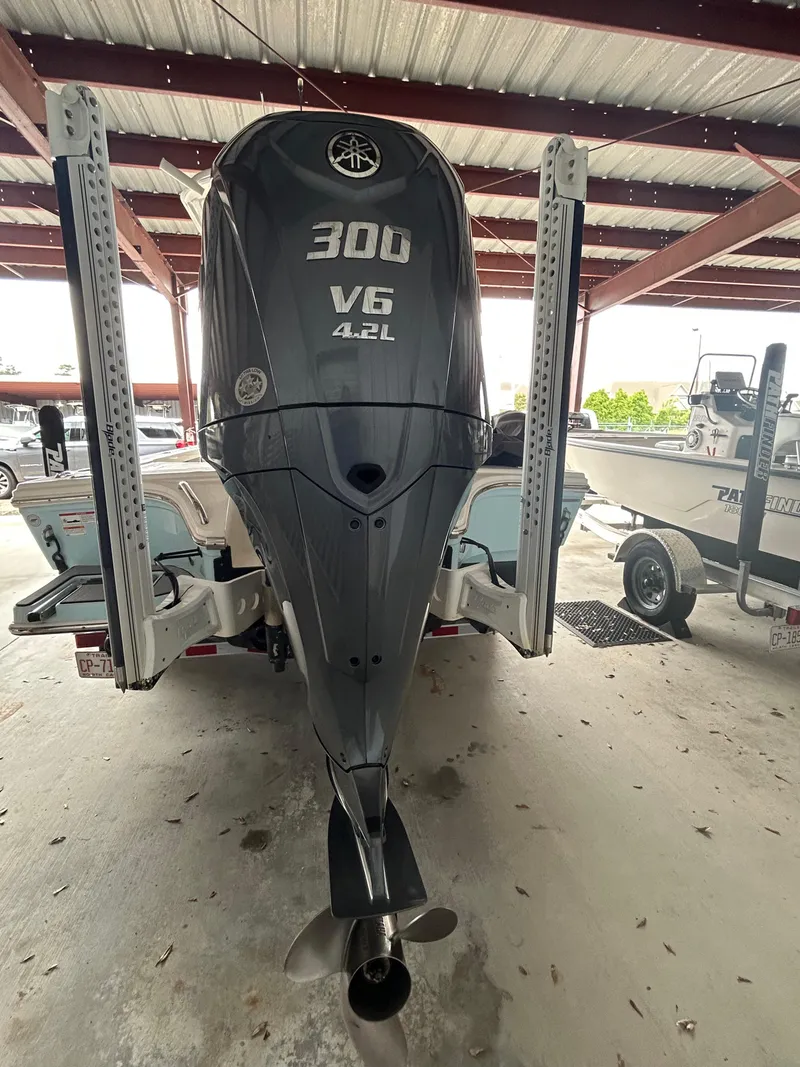 Slide: The Image of 2023 Pathfinder 2300 HPS boat under a metal roof, featuring a light fixture and rod holders. - 17