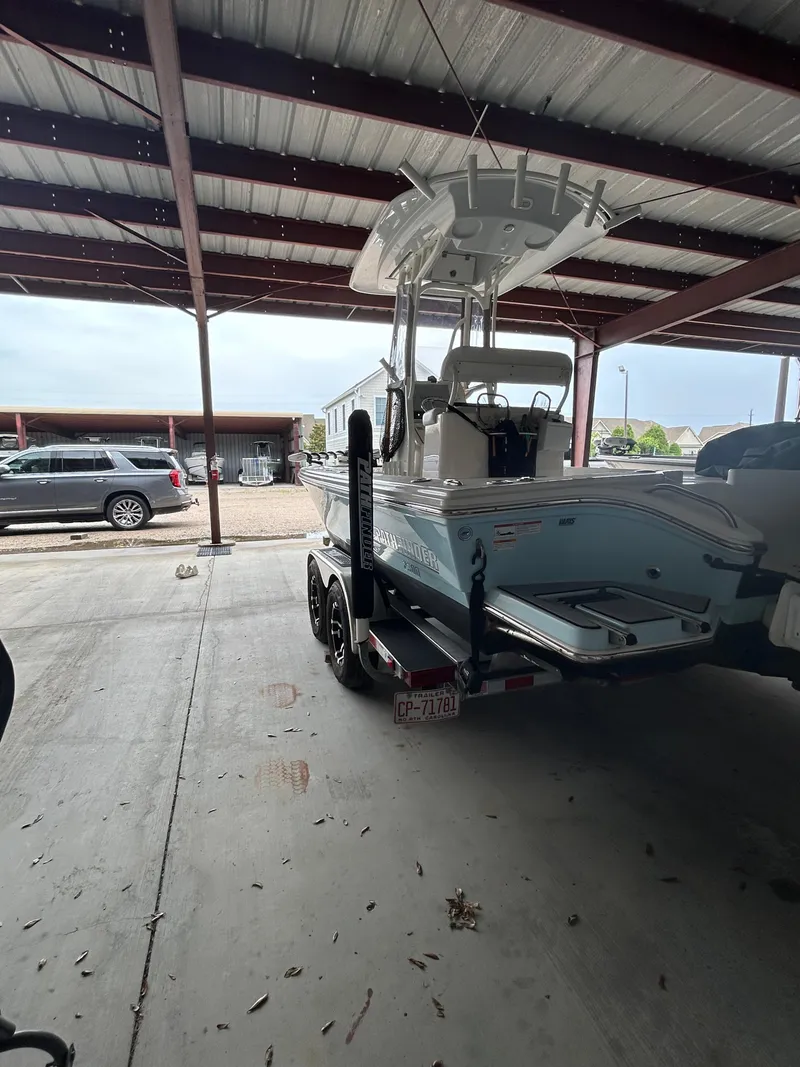 Slide: The Image of 2023 Pathfinder 2300 HPS boat with Yamaha outboard motor in covered storage. - 21