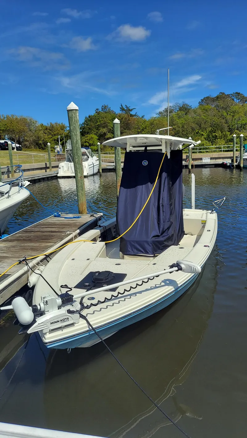 Slide: The Image of 2023 Pathfinder 2300 HPS boat docked in a marina with other boats under a clear blue sky. - 28