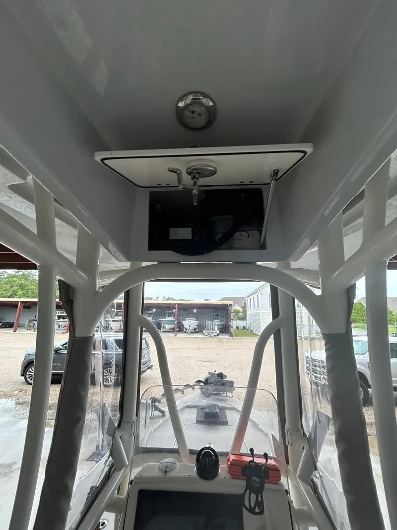 Slide: The Image of 2023 Pathfinder 2300 HPS boat interior with steering console under a metal roof. - 3